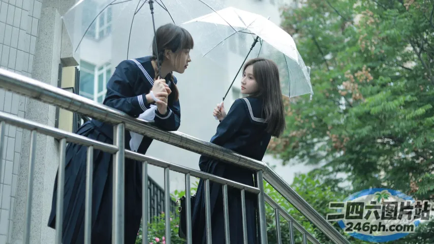 有两个人站在撑着雨伞的阳台上