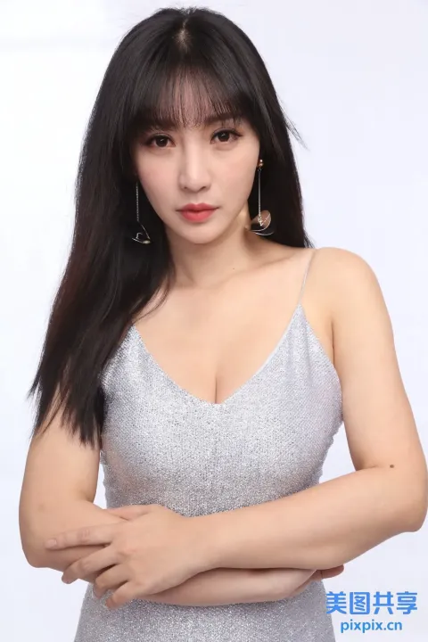 一个穿着银色连衣裙摆姿势拍照的女人的特写