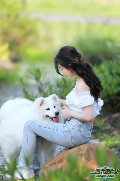 阿拉菲女子坐在岩石上，腿上抱着一只狗