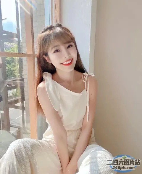 一个穿着白色连衣裙坐在床上的女人