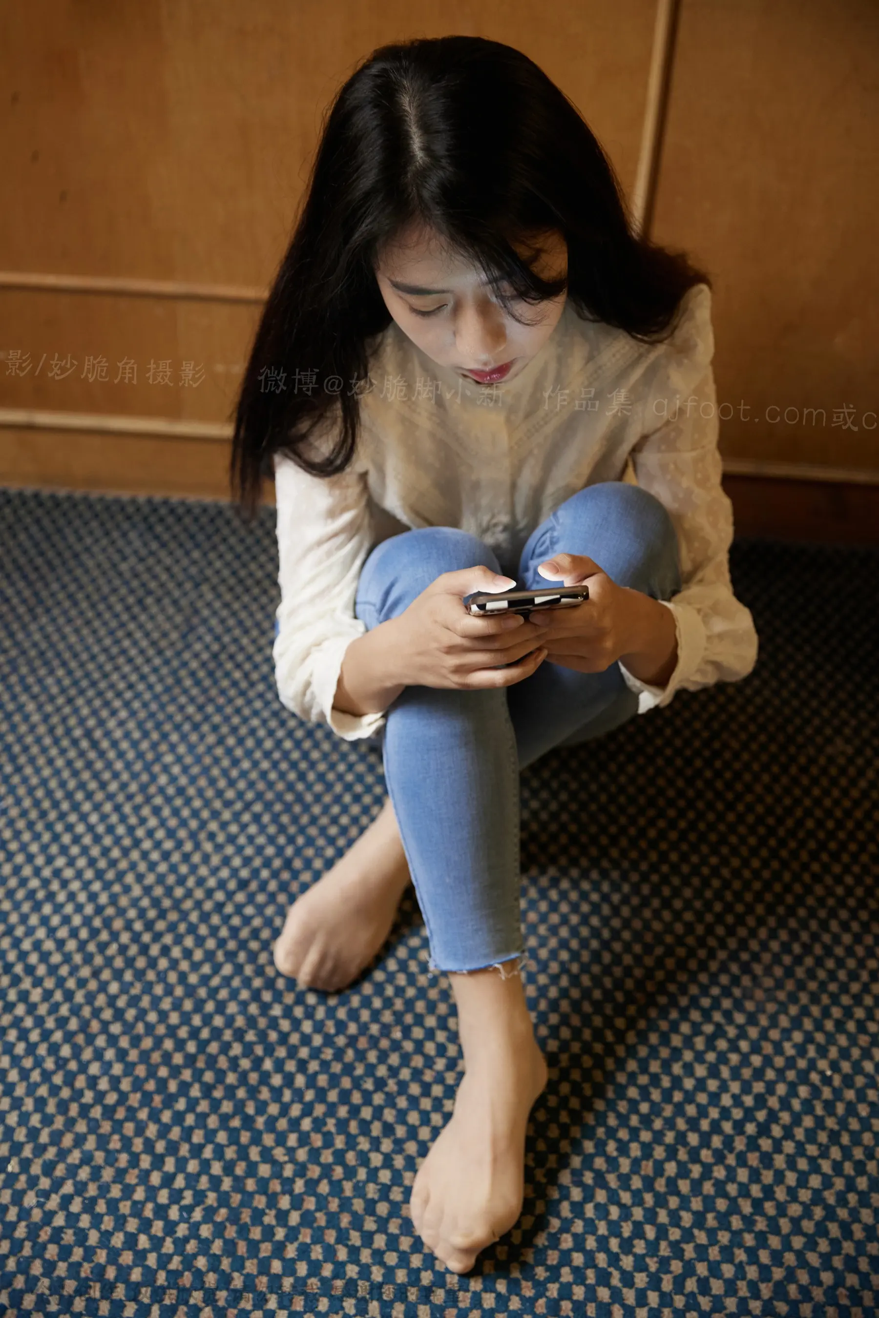 坐在地板上用手机的 arafed 女人
