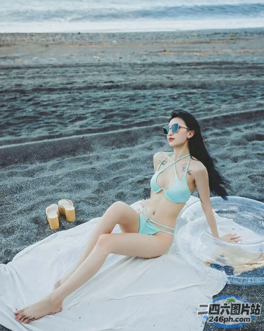 穿着比基尼坐在海滩上毛巾的 araffe 女人