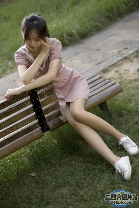 草地上的长凳上坐着一个女人