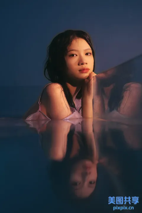 穿着粉红色连衣裙的阿拉夫德女人躺在玻璃桌上