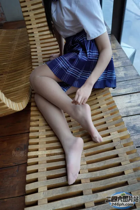 有个女人坐在木凳上，双腿交叉