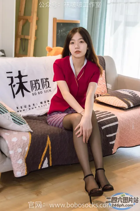 一个女人坐在房间里的沙发上，穿着红色衬衫