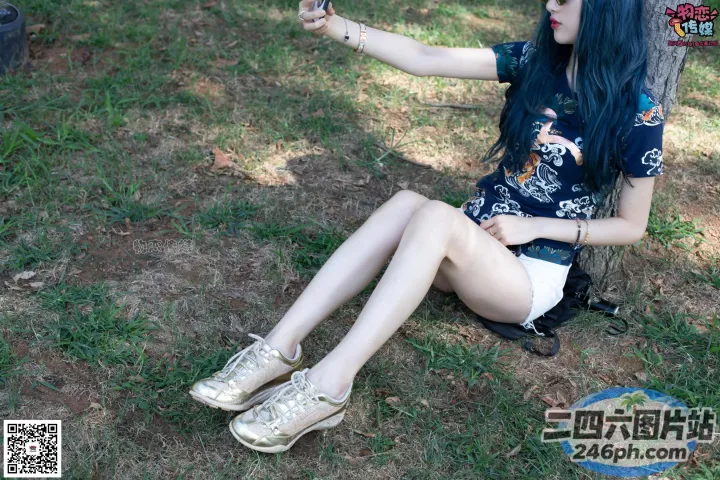 蓝发的 araffe 女孩坐在地上，手里拿着手机