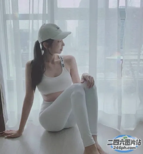 穿着白色上衣和白色裤子坐在地板上的 arafed 女人