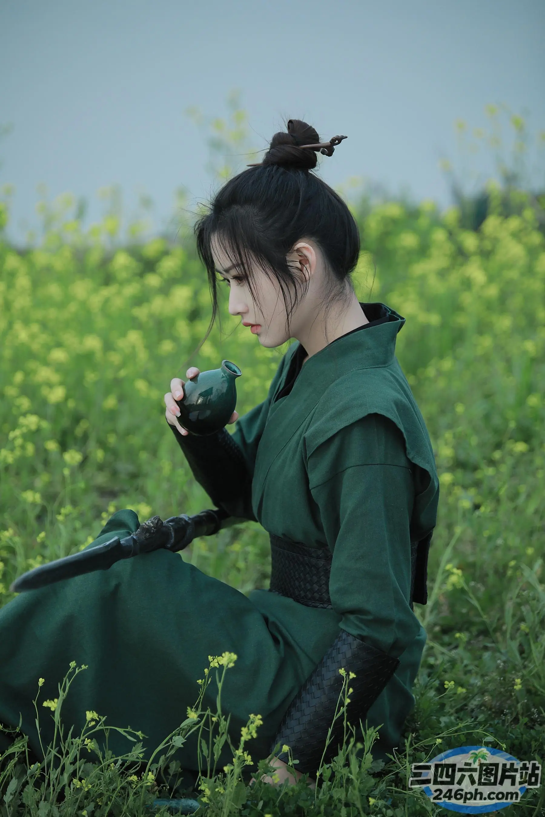 一个穿着绿色连衣裙的女人坐在花田里