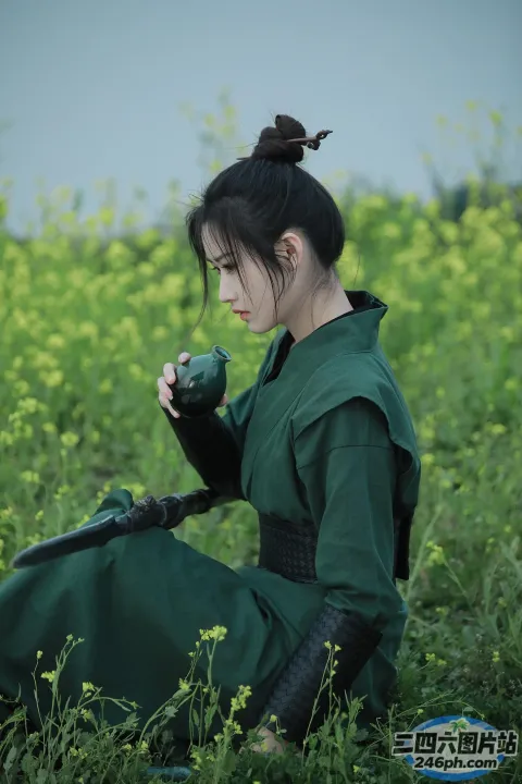 一个穿着绿色连衣裙的女人坐在花田里