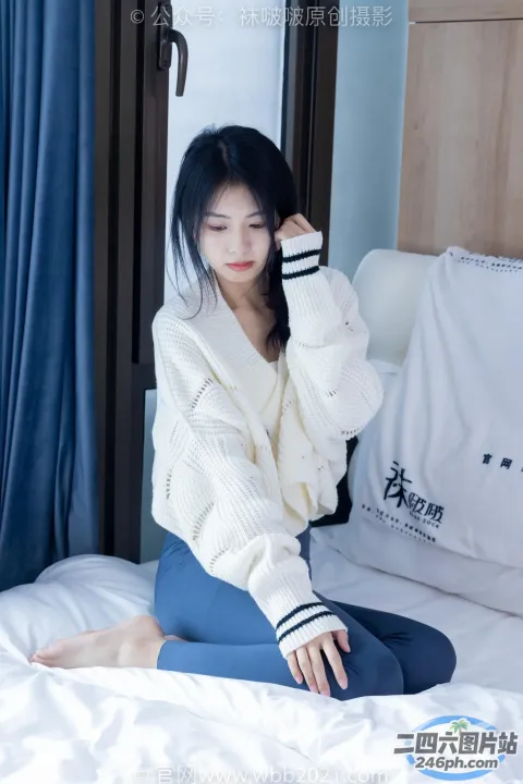 穿着白色毛衣坐在床上的阿拉夫德亚洲女子