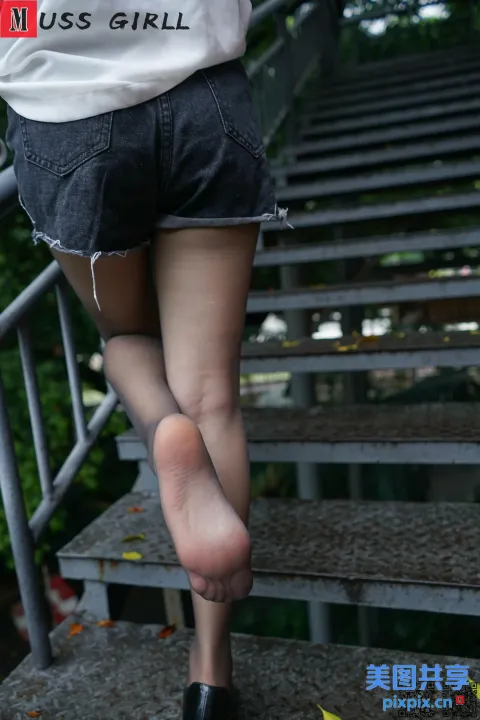 一名走上楼梯的女人的双腿和高跟鞋
