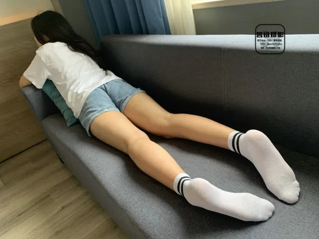躺在沙发上，双腿交叉的 Araffed 女人