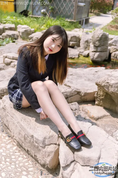 阿拉夫德亚洲妇女坐在岩石上，双腿交叉