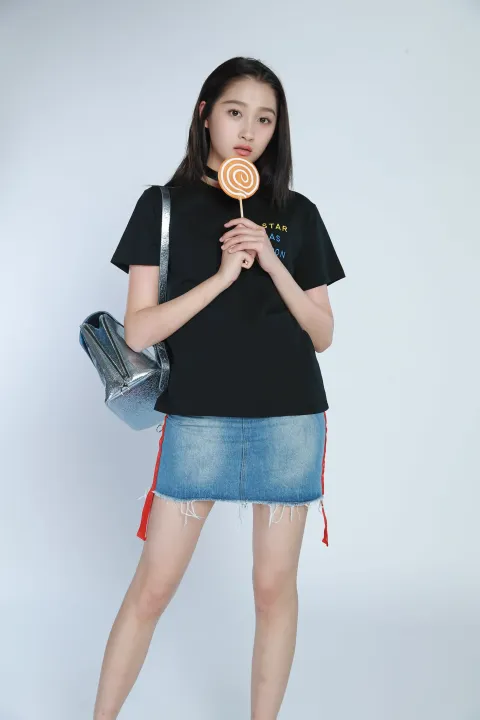 身穿黑色衬衫和牛仔裙的阿拉夫女人拿着棒棒糖