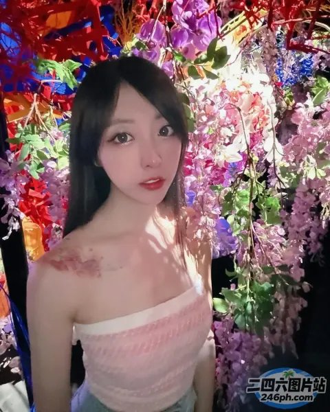 有一位女士在花墙前摆姿势拍照