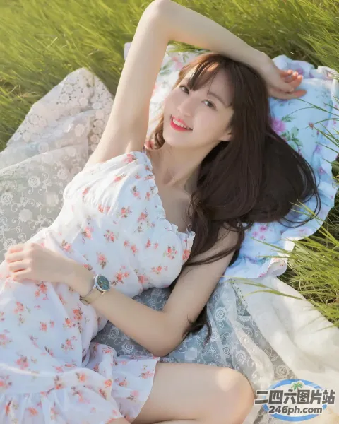 一个女人躺在草地上的毯子上