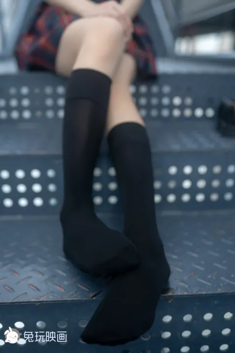 阿拉菲德女人坐在金属长凳上，双腿交叉