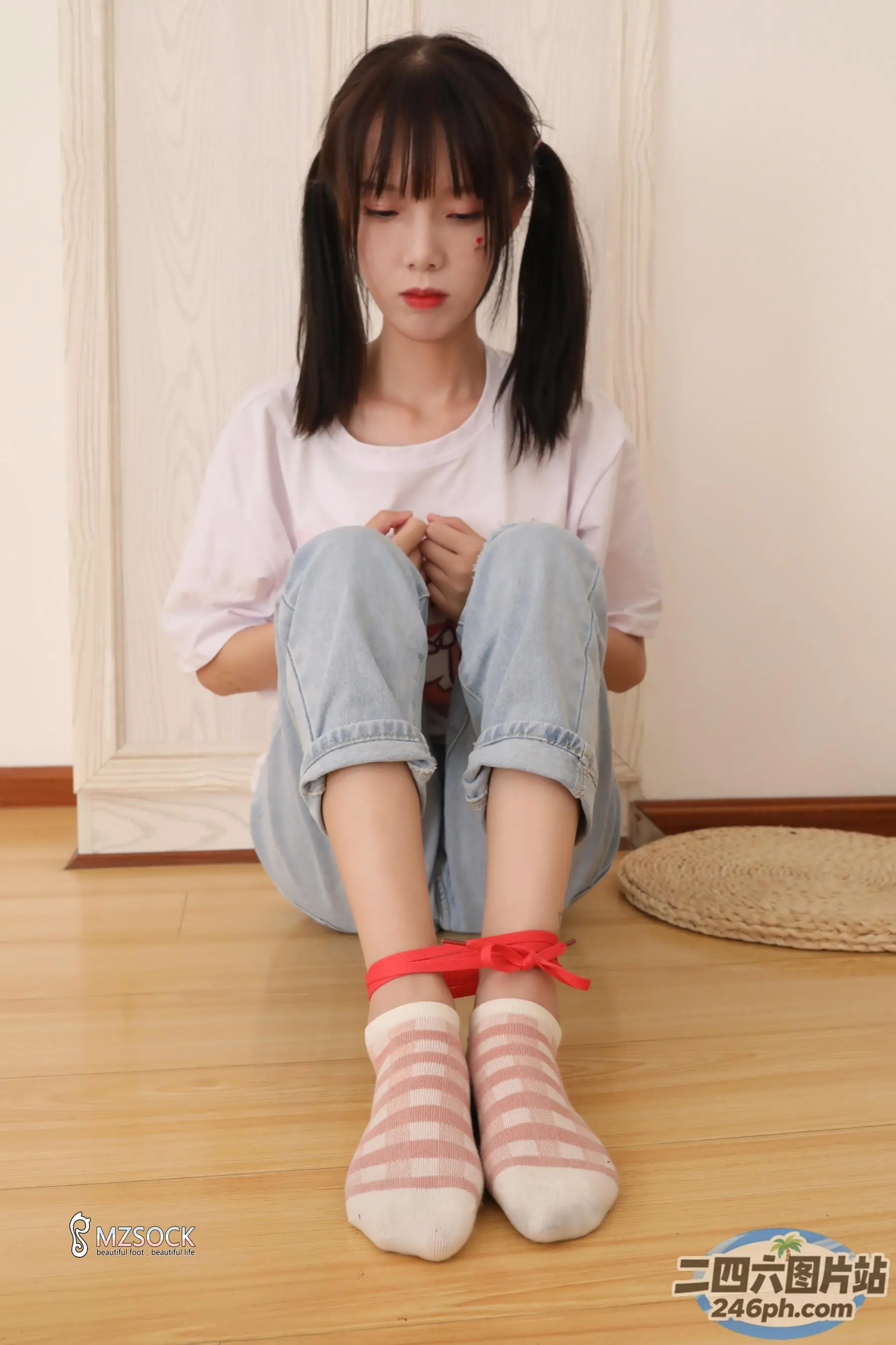 双叉坐在地板上的 arafed 亚洲女孩
