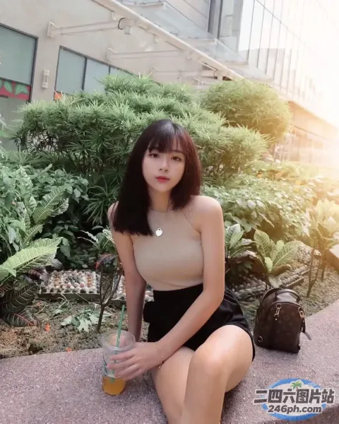 阿拉菲女人坐在地上，拿着饮料和一本书