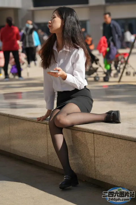 阿拉菲女子坐在窗台上拿着手机