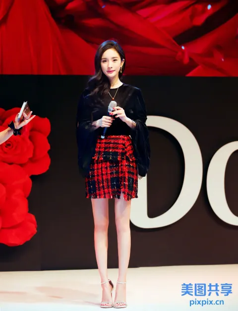 舞台上站着一个女人拿着手机