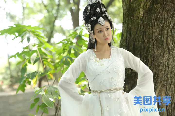 身穿白裙的阿拉夫女人站在树旁