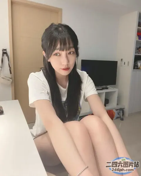 坐在床上拿着遥控器的阿拉菲德女人