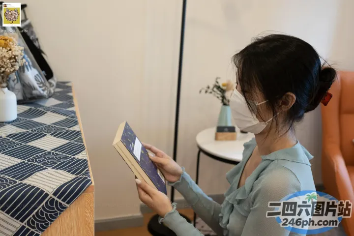坐在桌子旁的女人在花瓶前看书