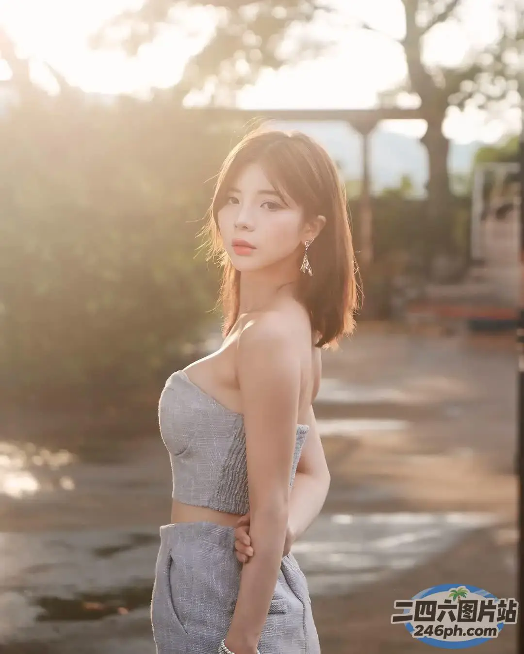 一名身穿灰色连衣裙的女子站在一栋建筑前