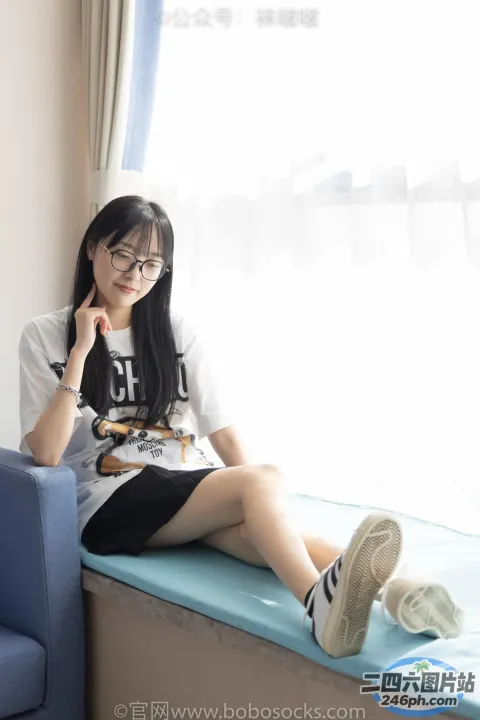 阿拉菲坐在床上，手里拿着一本书和一杯咖啡