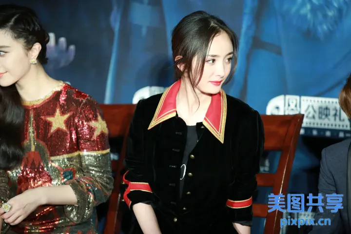 长凳上坐着两个女人，一个穿着红色和金色的夹克
