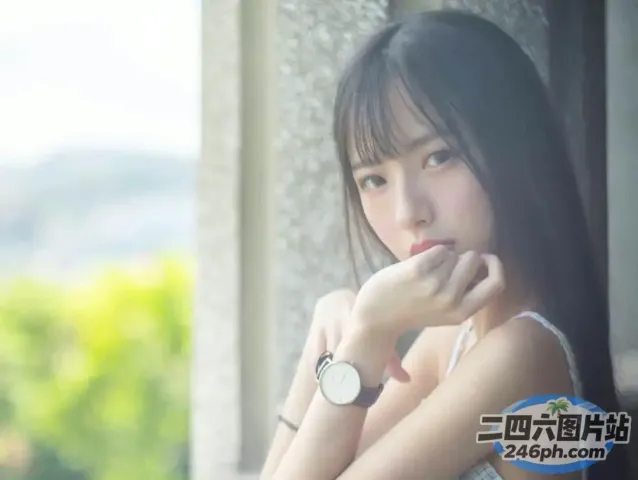 有个女人坐在窗边，手里拿着手表