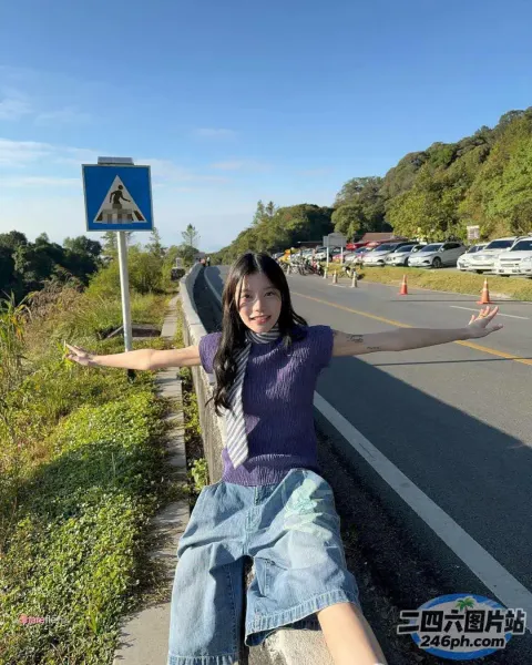 路边的墙上坐着一个女人