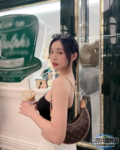 身穿黑色连衣裙的 araffe 女子，手里拿着一杯咖啡