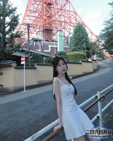 身穿白色连衣裙的阿拉夫德女子站在一座红色的桥前