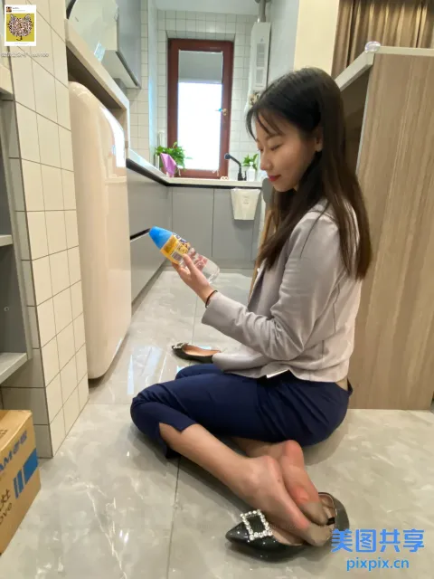坐在地板上的女人拿着一瓶水和一部手机
