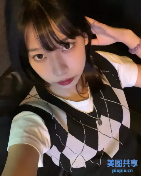 穿着黑白毛衣背心和白衬衫的 Arafed 女人