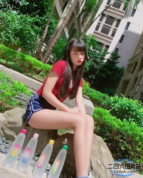 阿拉菲坐在一块石头上，手里拿着瓶装水和一瓶水