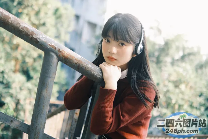 有个女人戴着耳机站在栏杆上