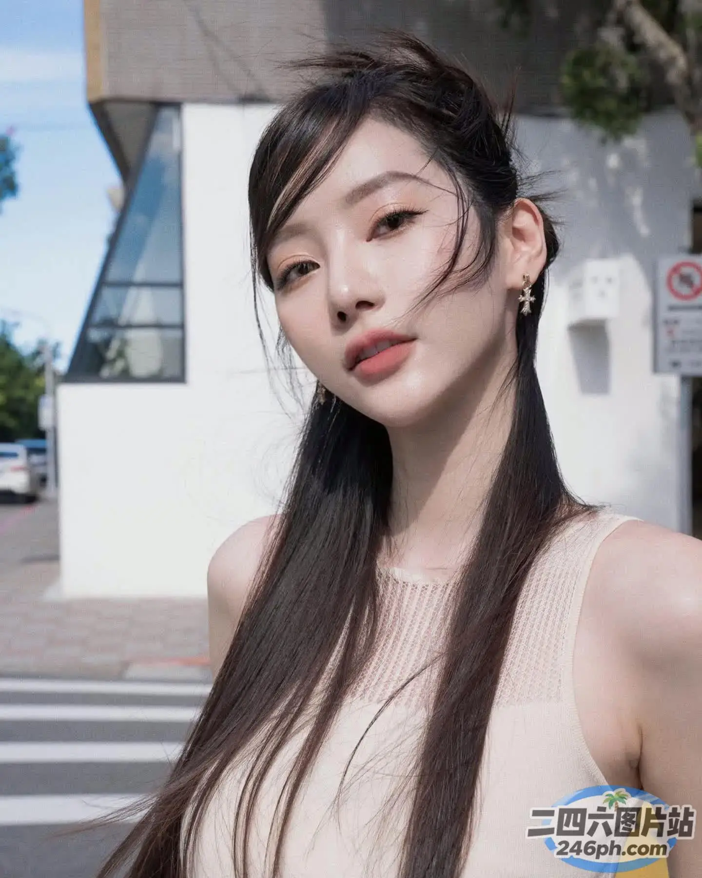 一位留着长发的女人站在一栋建筑前