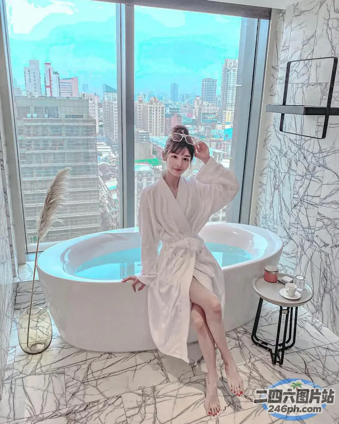 坐在浴室浴缸里的女人，可以看到城市的景色