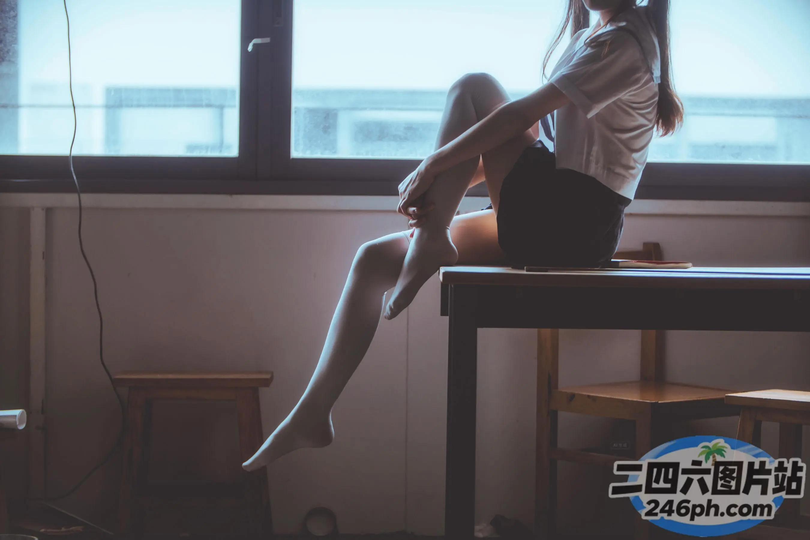 有一个女人盘着腿坐在桌子上