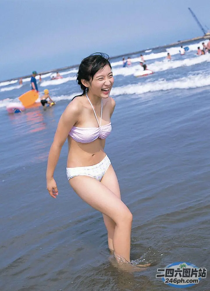 穿着比基尼的女人站在海滩的水中
