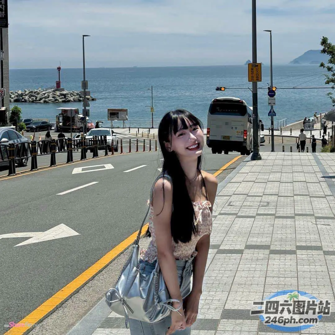水边的人行道上站着一个女人