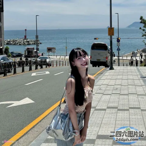 水边的人行道上站着一个女人
