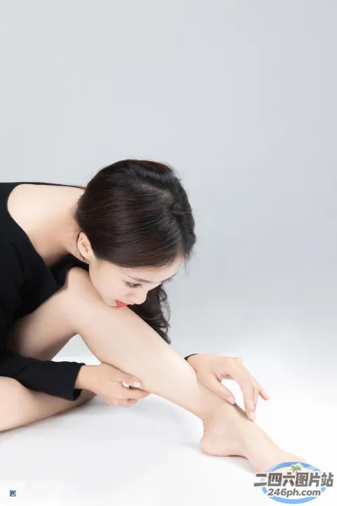 有一个女人坐在地上，双腿交叉