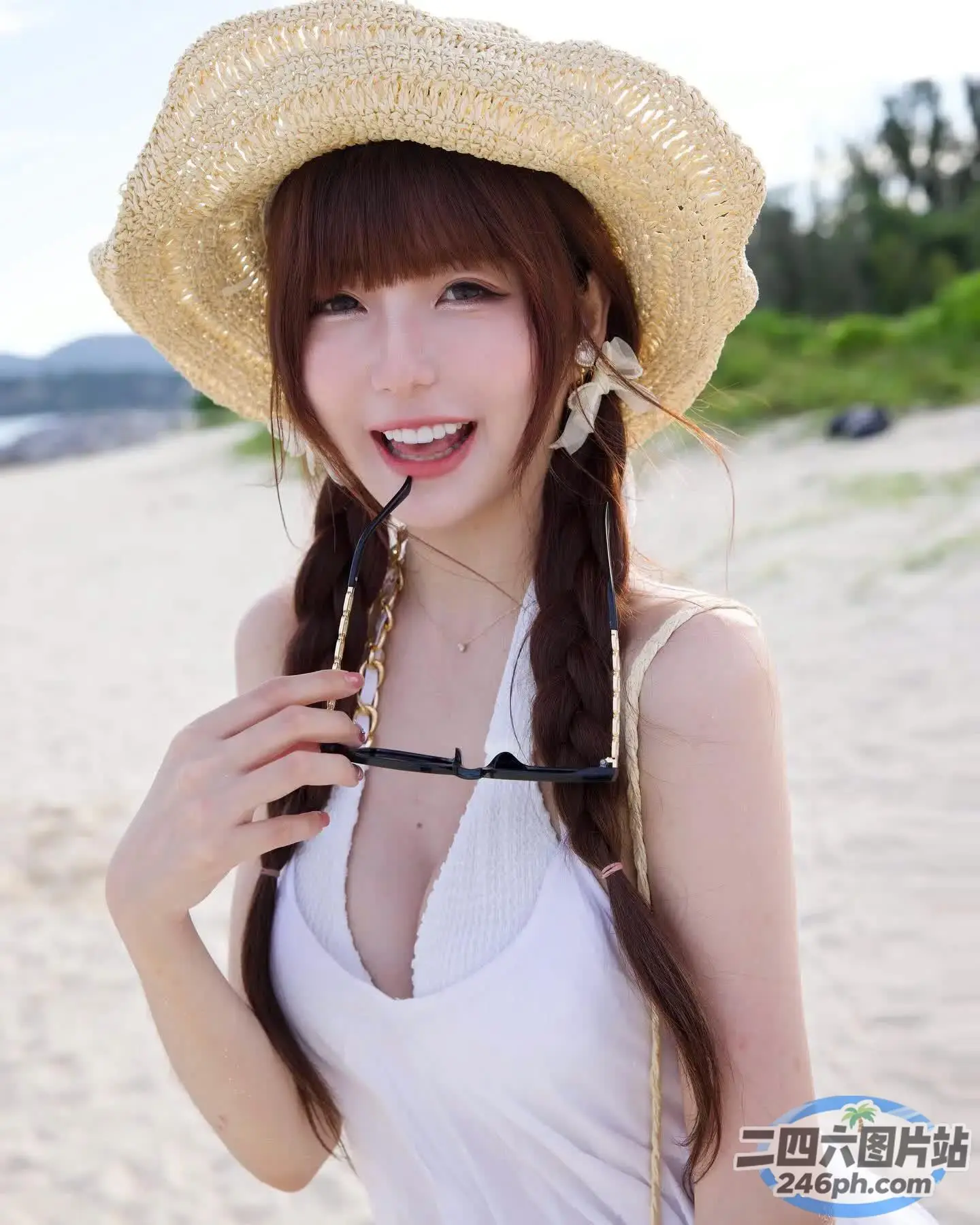 海滩上戴着草帽和墨镜的 araffe 女孩