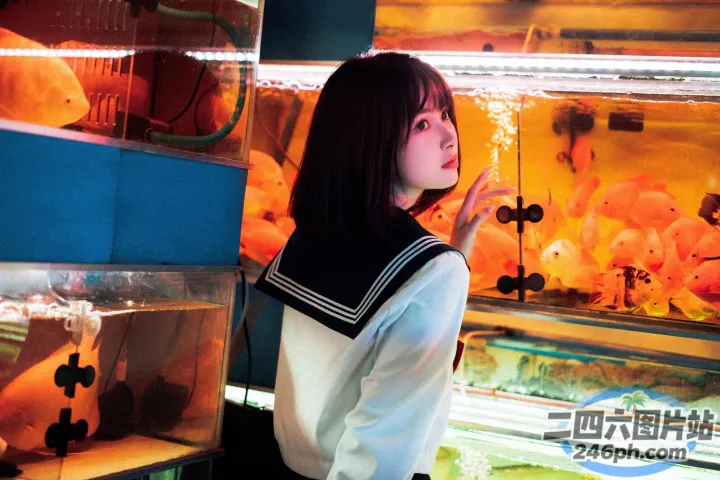 有一个女人站在一个鱼缸前