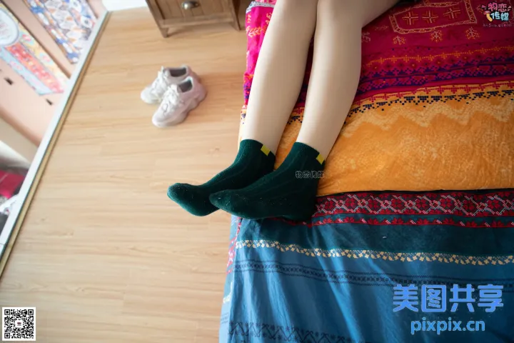 阿拉夫的腿躺在床上，铺着彩色毯子和一双袜子